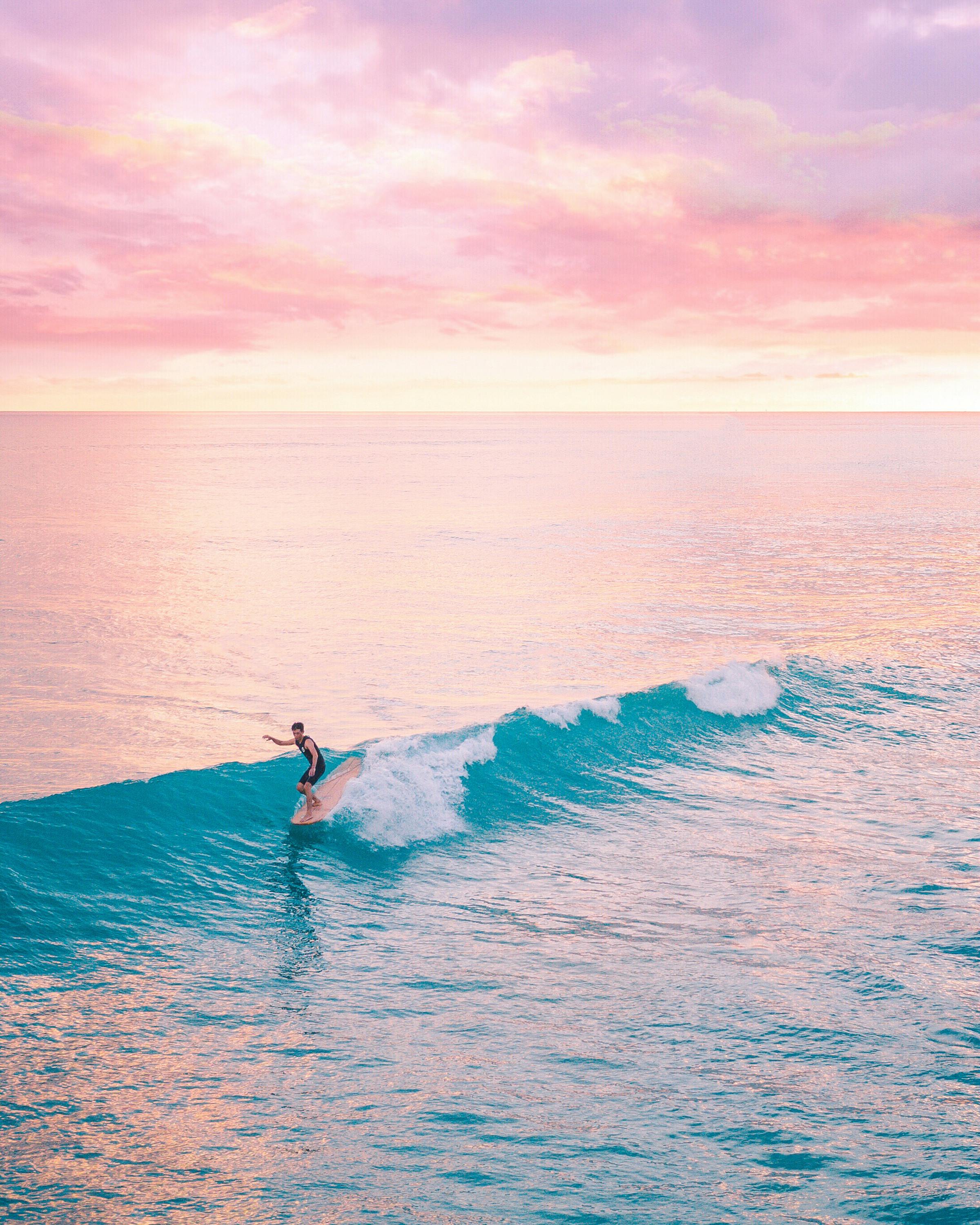 Surfer riding wave at sunset in Essaouira
